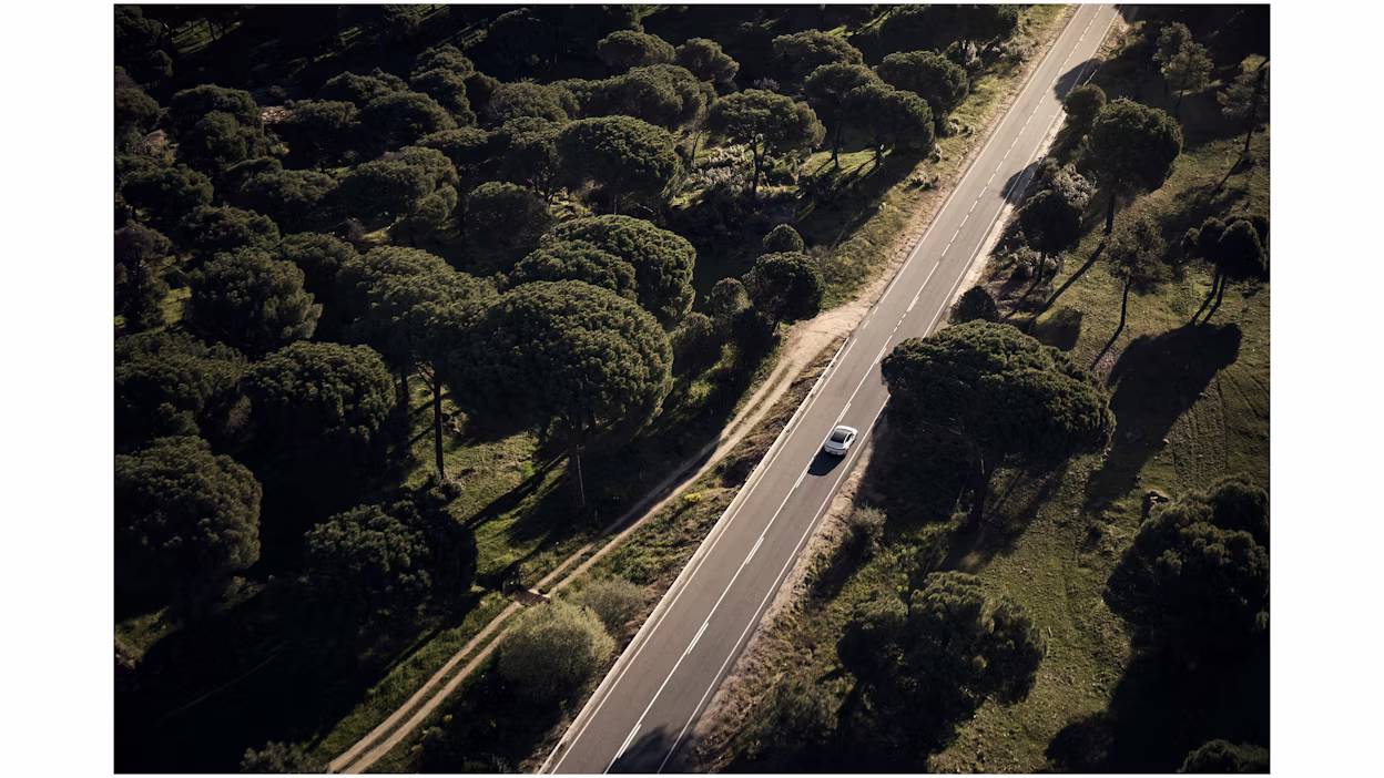 Polestar 4 rijdt op een lege weg vanuit de lucht gezien.