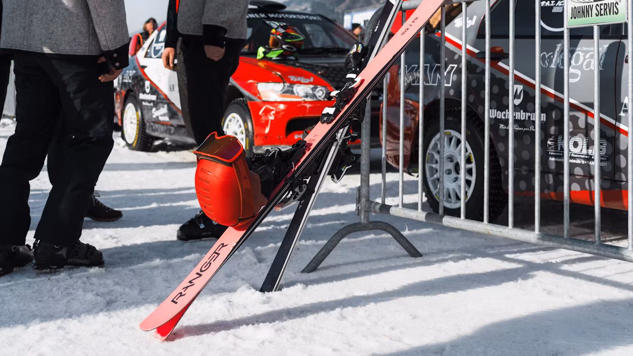 Skiing equipment in front of race cars
